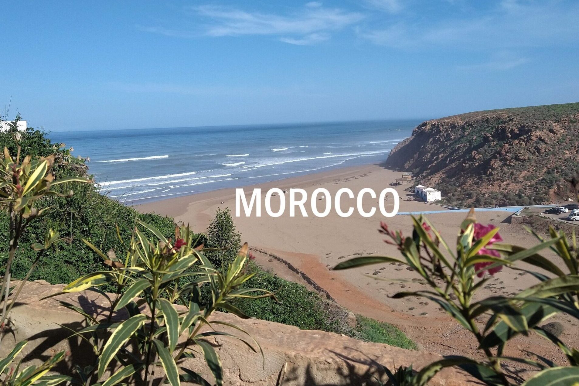 small valley running down to beach, open sandy bay and small surf, morocco